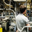 A man and a woman are standing in a room with multiple conveyor belts.