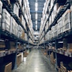 There is a warehouse with lots of packets stacked on shelves.