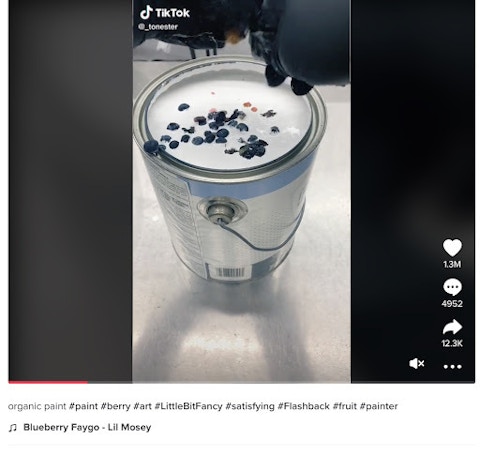 Screenshot of a TikTok video with 1.3 million views; an artist is dripping dark blue paint into a bucket of white paint.