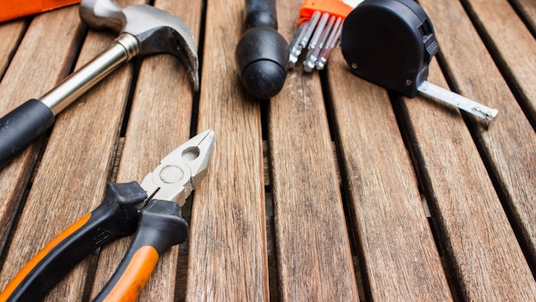 Some construction tools sit on a wooden structure.