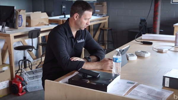 A man sits at a table with a laptop.
